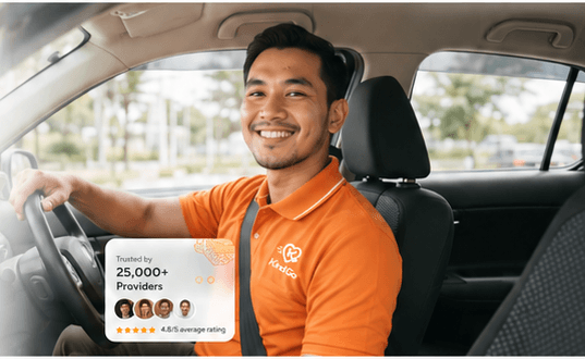 KindGo driver partner in orange polo smiling in his car